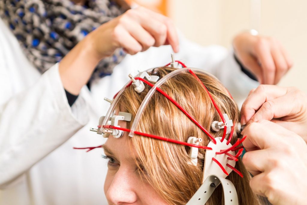 Bei einer Patientin wird ein EEG durchgeführt.
