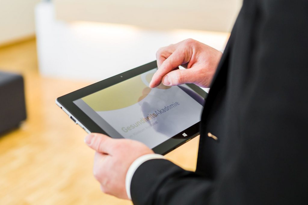 Ein Mann hält ein Tablet.