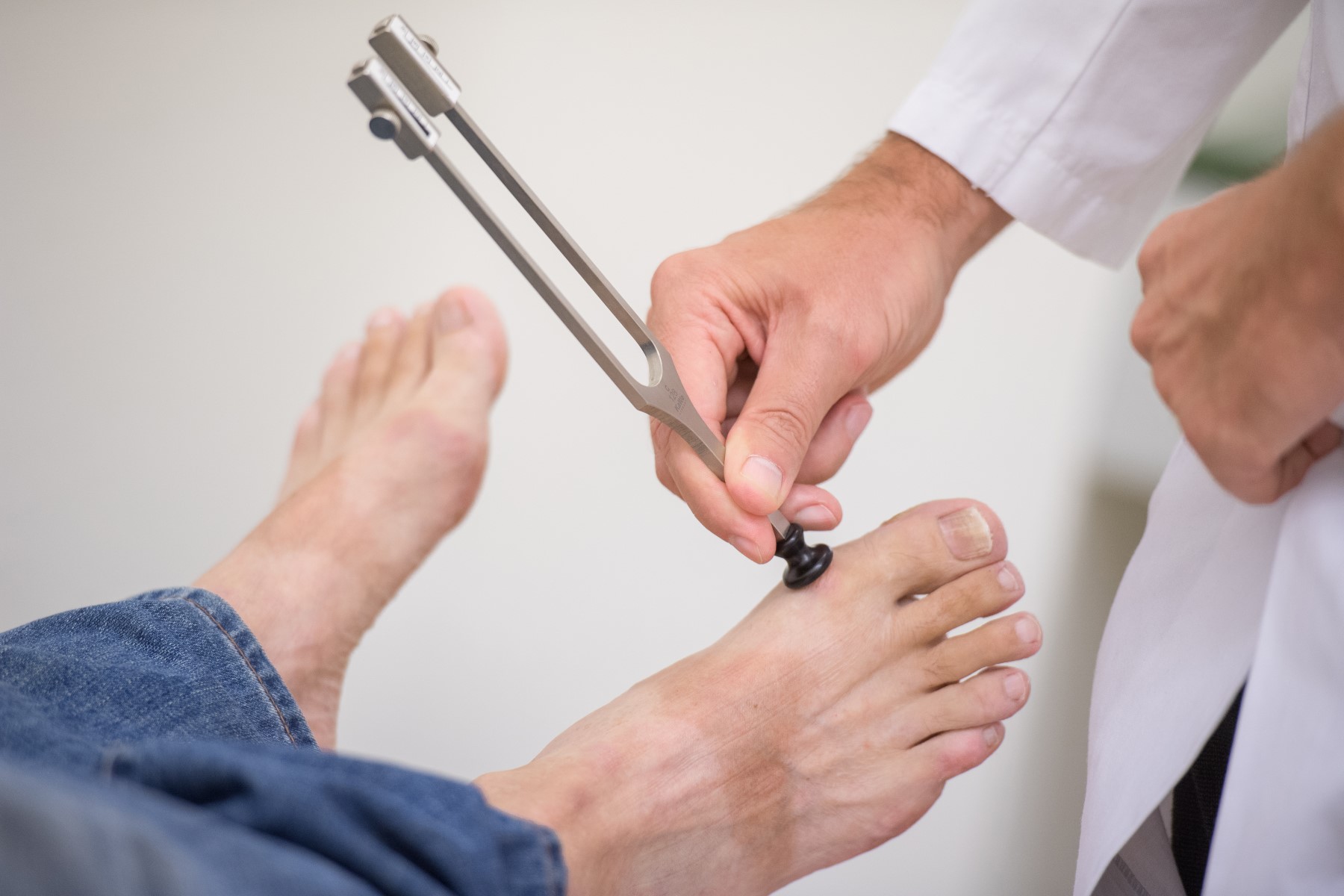 Stimmgabeltest am Fuß eines Patienten