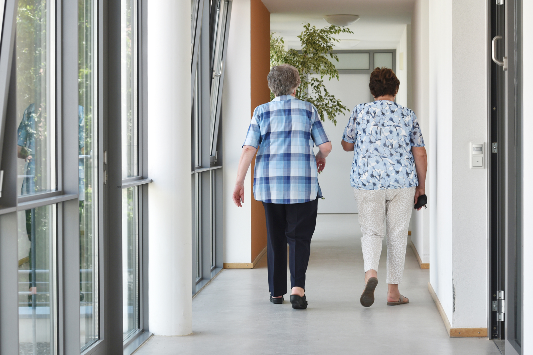 Zwei ältere Damen gehen einen Flur entlang